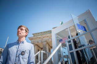 Eine Person steht vor dem gläsernen Container