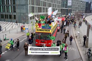 Roter Doppeldeckerbus mit Bannern in Berlin