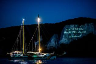 ECHTER SCHUTZ FÜR UNSERE MEERE ist am Kreidefelsen nahe der Insel Rügen als Projektion in der Nacht zu lesen.  Die Beluga-II ist im Juli und August 2020 in den Schutzgebieten der Nord- und Ostsee unterwegs. Ihre Mission ist es, "echte Schutzgebiete" ohne menschlichen Raubbau einzurichten, wo sich die Natur erholen kann. 