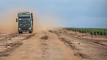 LKW auf Lehmpiste, ödes Land und Soja-Feld