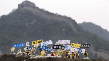 Protestierende Legofiguren vor der chinesischen Mauer