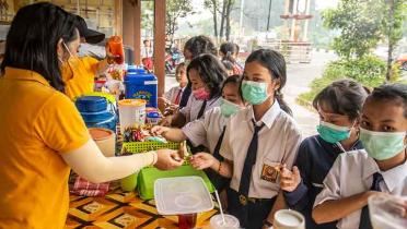 Kinder auf einem Schulhof in der Stadt Palangkaraya, Zentral-Kalimantan, tragen Atemschutzmasken