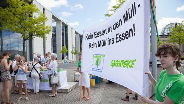 Jugendliche protestieren mit Bannern gegen Lebensmittelverschwendung