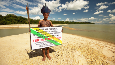 Angehöriger der Munduruku mit einem Schild, das symbolisch das Gebiet des Indigenen-Volkes markiert