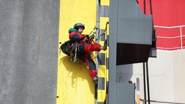 Kletterer am Schiffsrumpf der Elbe Highway