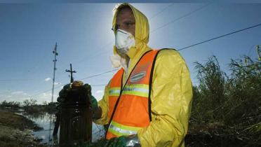 Greenpeace Kampaigner Mark Floegel mit einer Probe des Flutwassers neben der Shell Ölindustrie, September 2005