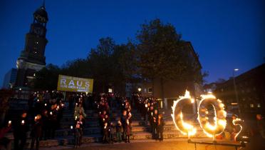 Menschen mit Laternen, Bannern und einem brennenden CO2 Schriftzug in Hamburg