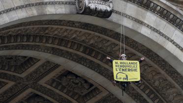 Kletterer am Triumphbogen mit Banner