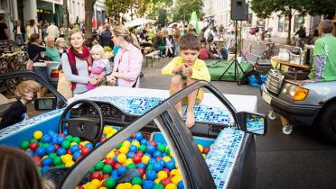 Ein zum Bällebad umgebautes Auto lockt Kinder an