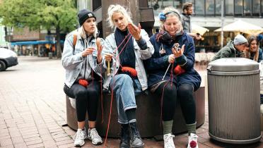 Studentinnen beim Stricken in der Fußgängerzone