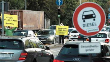 Aktivisten im Straßenverkehr mit Bannern und Warnschild