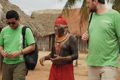 Greenpeace-Mitarbeitende reden mit Kayapó Indigenem