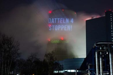 Aktivistinnen und Aktivisten projizieren verschiedene Bilder auf den Kühlturm des Kohlekraftwerks Datteln 4