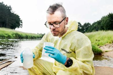 Dirk Zimmermann, Experte für Landwirtschaft bei Greenpeace, nimmt Wasserproben aus dem Fluss Hase im Landkreis Oldenburg