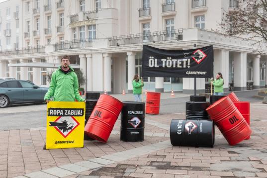 Protest gegen russische Schattenflotte mit Ölfässern und einem Banner "Öl tötet"