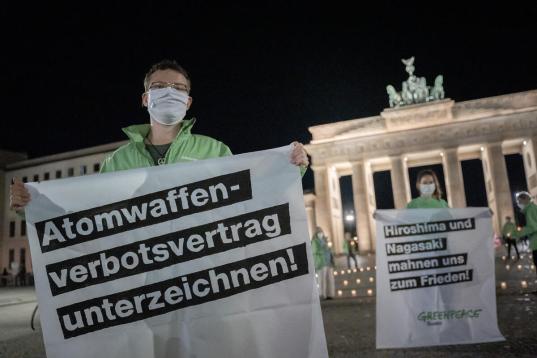 Leuchtendes Friedenszeichen mit hunderten Kerzen am Brandenburger Tor zum Gedenken an den Abwurf der Atombombe auf Hiroshima.