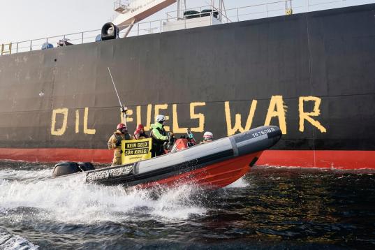 Greenpeace-Aktivist:innen demonstrieren im Fehmarnbelt mit einem Schlauchboot gegen Ölimporte aus Russland, die Putins Krieg in der Ukraine mitfinanzieren. Die Aktivist:innen malen "OIL IS WAR" auf die Seite des Tankers "Stamos", der Rohöl aus dem russischen Ostseehafen Ust-Luga nach Rotterdam liefert.