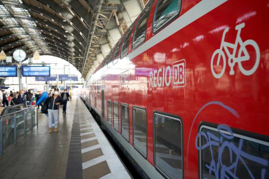 Bahn mit einem Fahrradsymbol an einem Wagon fährt in den Bahnhof