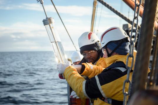 Zwei Greenpeace-Aktivisten halten eine sogenannte Niskin-Flasche, mit der sie Wasserproben nehmen.