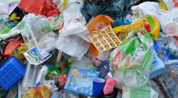 Kinder mehrerer Greenteams stehen neben einem großen Haufen Plastik und informieren über die Verschmutzung der Ozeane mit Plastikmüll. 