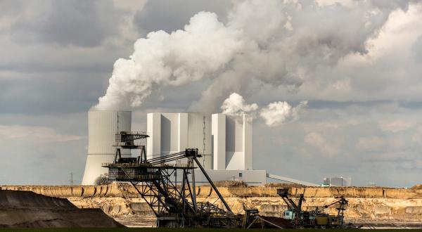 Braunkohlekraftwerk Lippendorf: Kühltürme und Schornsteine mit Rauch, davor Bagger im Braunkohletagebau