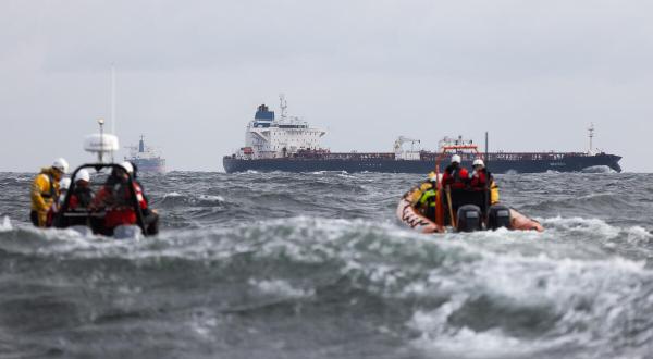 zwei Schlauchboote mit Aktivist:innen auf der Ostsee, im Hintergrund das Schiff