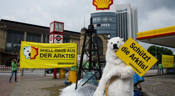 Ein als Eisbär verkleideter Greenpeace-Freiwilliger hält ein Schild mit der Aufschrift: "Rettet die Arktis!" hoch. Mit der  Aktion an einer Shell-Tankstelle in  Hamburg fordert Greenpeace  ein globales Schutzgebiet rund um den Nordpol und ein Verbot von weiteren Ölbohrungen in der Arktis.  