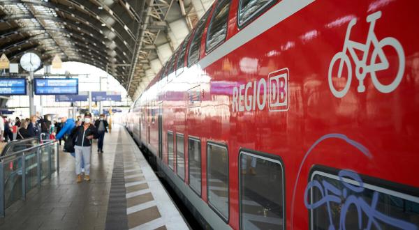 Bahn mit einem Fahrradsymbol an einem Wagon fährt in den Bahnhof