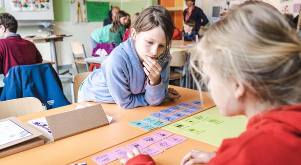 Schüler:innen arbeiten im Klassenraum mit Kärtchen zum Thema Klima und Nachhaltigkeit