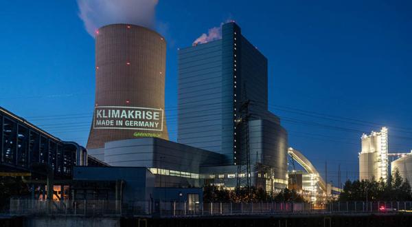 Greenpeace-Aktivistinnen und -Aktivisten projizieren auf den 180 Meter hohen Kühlturm des Kraftwerks Datteln 4 „Klimakrise – Made in Germany“.