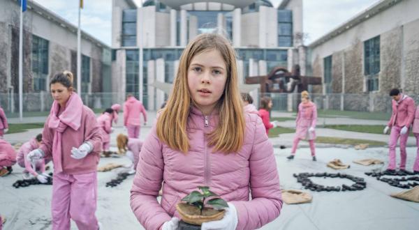 Mädchen in Rosa mit Bäumchen vor Kanzleramt in Berlin