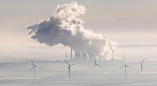 Kohlekraftwerk und Windräder im Morgennebel