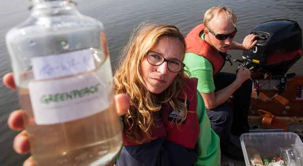 Greenpeace-Aktivisten nehmen von einem Schlauchboot aus Wasserproben aus der Schlei in Schleswig Holtein.