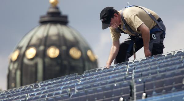 Arbeiter bei Wartungsarbeiten an einer Photovoltaikanlage in Berlin, Juli 2009