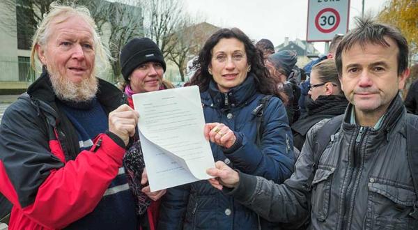 Bürger halten eine Strafanzeige u. a. gegen den Atomkonzern EDF vor der Polizeistation in Thionville hoch - wegen Gefährdung Dritter.