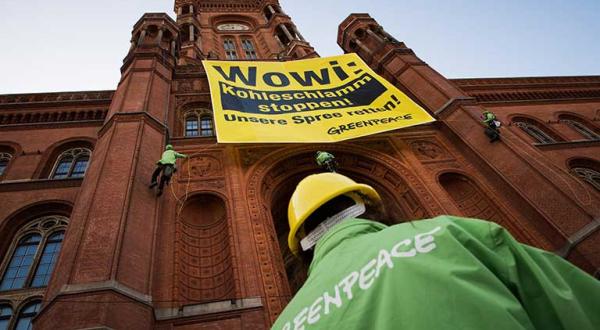 19.08.2014: Greenpeace-Aktivisten protestieren vor dem Roten Rathaus in Berlin mit rotem Schlamm gegen die Verockerung der Spree durch den Braunkohletagebau