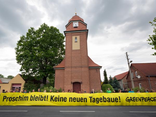 Protestaktion mit einem Banner gegen Tagebau