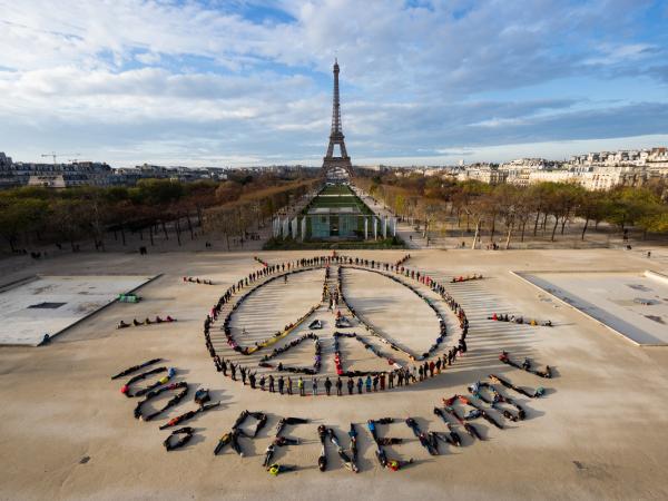 Hunderte Menschen bilden visuelle Klimaschutzbotschaft am Eiffelturm in Paris