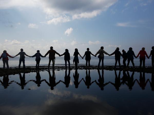 Menschen halten sich an einem Strand in Molyvos, Lesbos, an den Händen und fordern eine sichere Überfahrt und keine weiteren Toten. 