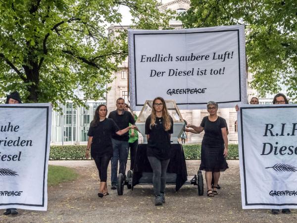 Greenpeace-Aktivisten tragen einen Dieselmotor in einem Sarg und fordern das Aus für den Diesel.