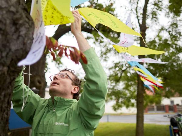 Greenpeace-Ehrenamtlicher hängt Wimpel auf